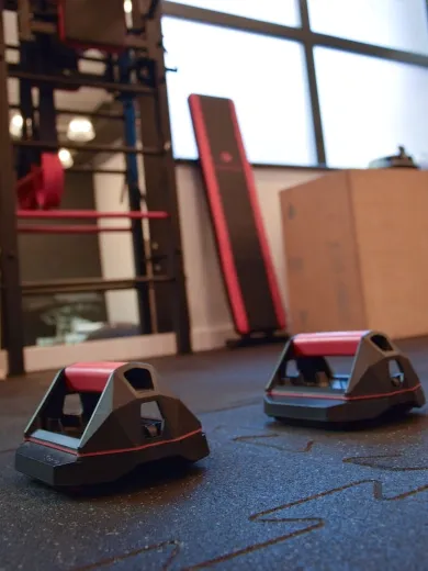 Sala treningowa wyposażona w drabinkę, lustro i paraletki do ćwiczeń